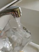 Robinet qui fait coule de l'eau dans un verre dans lévier. 